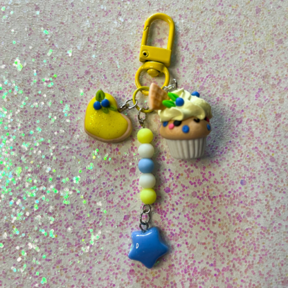 blueberry lemon cupcake charm with lemon frosting and an additional heart shaped lemon cookie charm