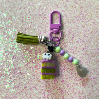 Green cake slice clay charm with a skull and purple frosting